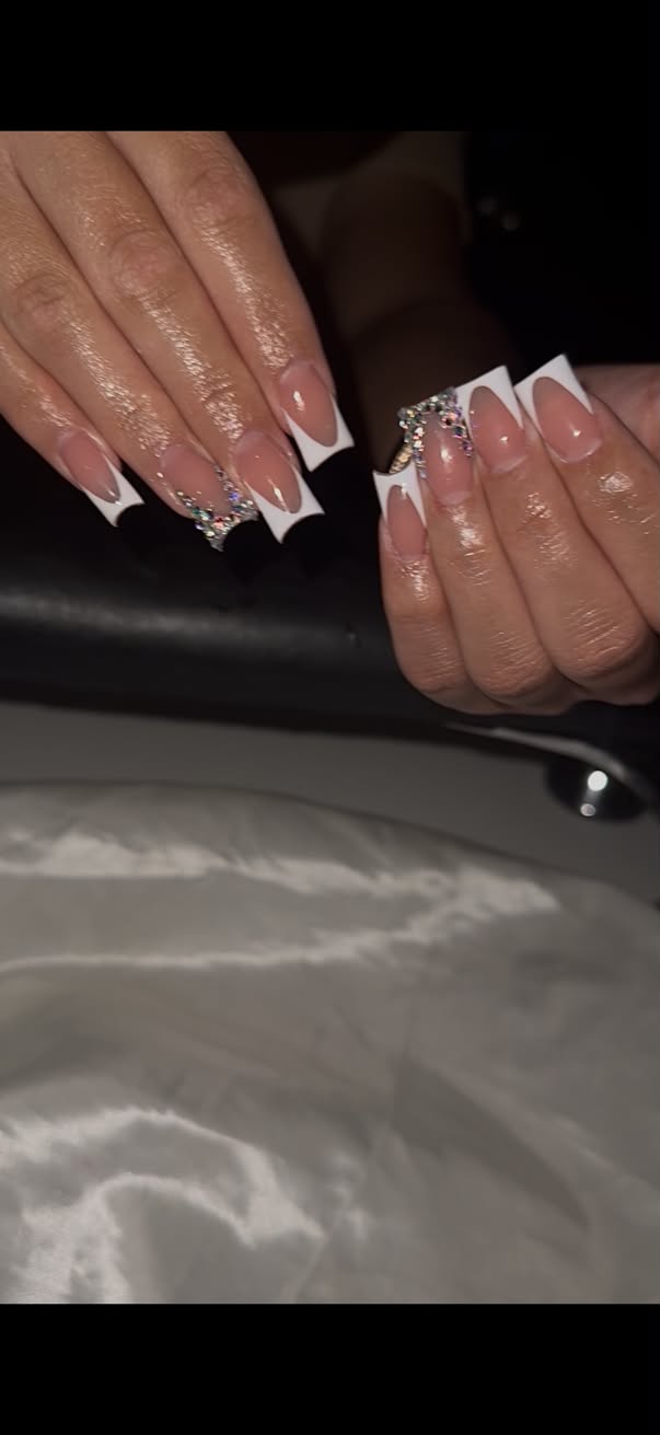 Long square nails with nude French tips and crystal accents